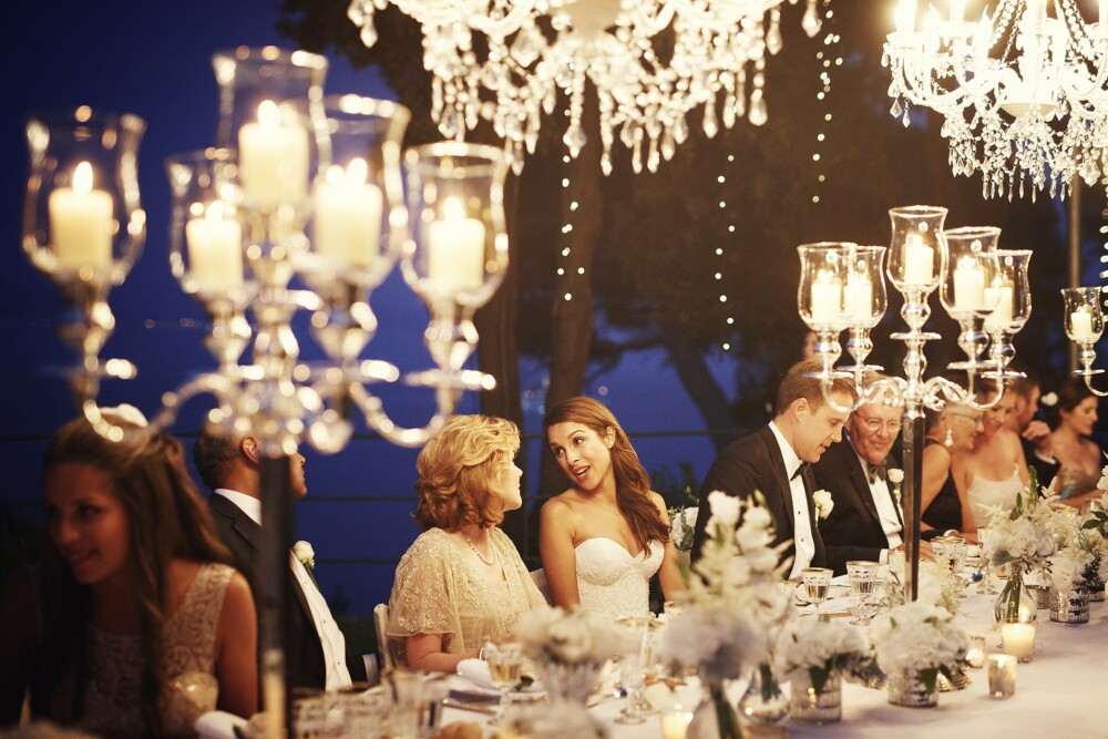 Bride and mother of the bride in the frame of hanging chandeliers and candelabras