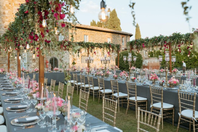 Tables with pink and burgundy decor at elegant wedding villa in Italy