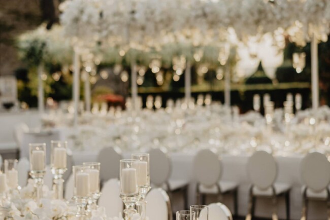 Wedding white tables at the sunset with cascading orchids