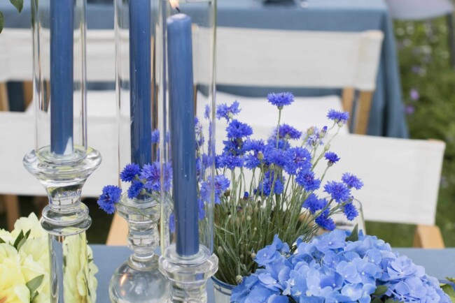 Table with glass candles and blue flowers
