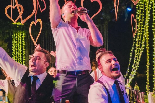 Singer and bartenders at party with hanging hearts