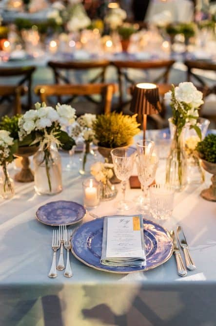 Blue plates and white flowers with herbs set up