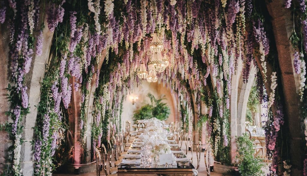 Falling wisteria with chandeliers over long table