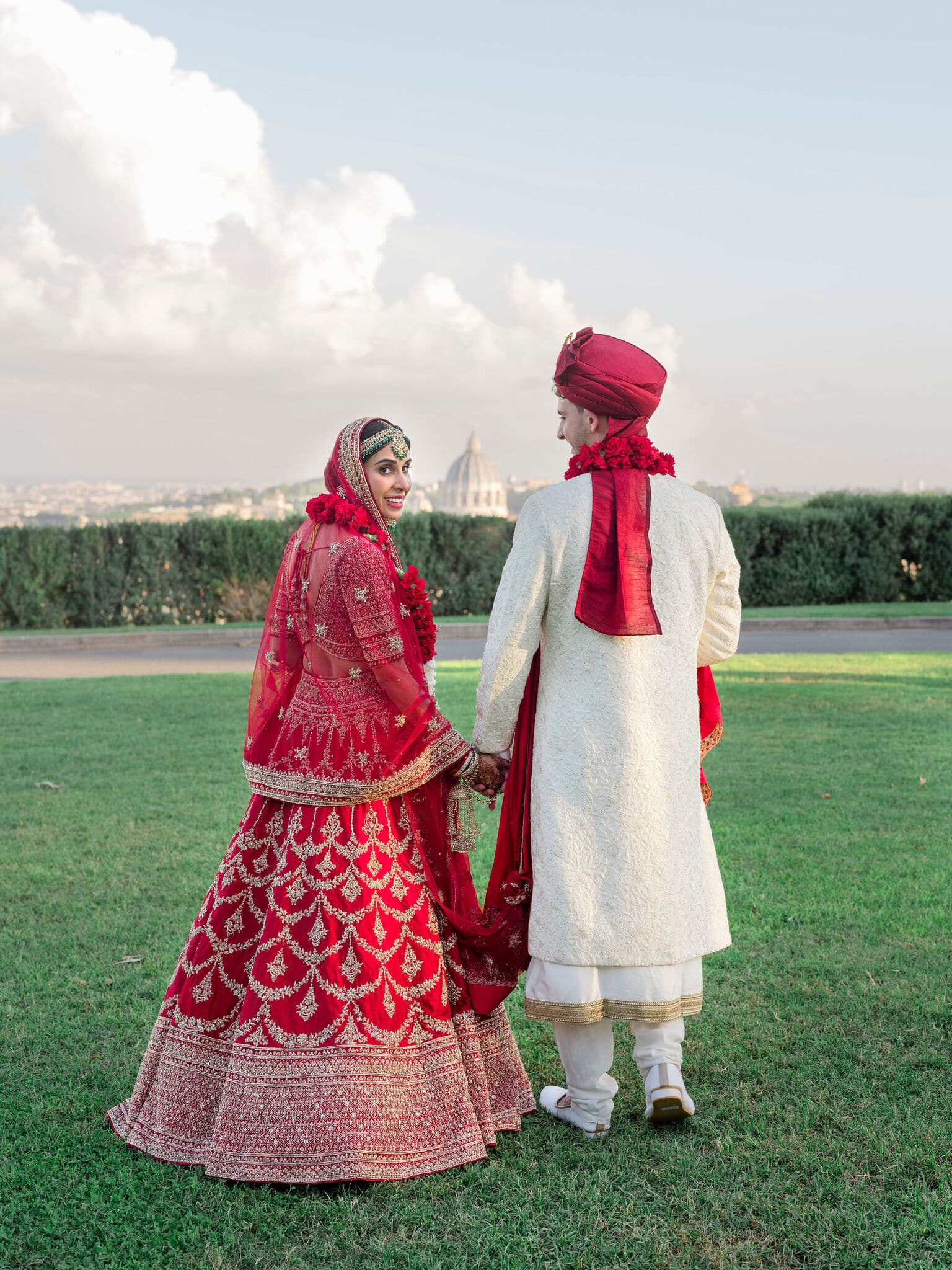 Bride and groom with red Indian dresses at the wedding villa in Rome